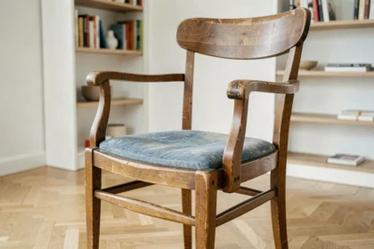 Chaise en bois vintage de marque en bon état posée dans un salon scandinave minimaliste, illustrant la durabilité des chaises d'occasion de qualité