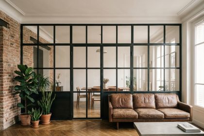 Verrière industrielle en acier noir séparant salon et salle à manger dans un appartement haussmannien rénové